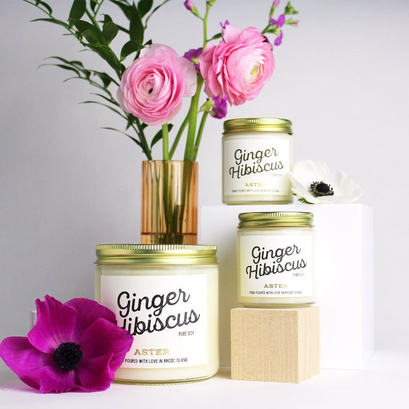 Large and mini Ginger Hibiscus scented soy candles pictured with vase and flowers.