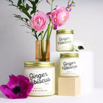 Load image into Gallery viewer, Large and mini Ginger Hibiscus scented soy candles pictured with vase and flowers.
