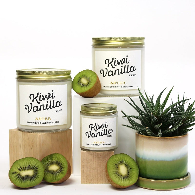 Large and mini Kiwi Vanilla scented soy candles pictured with sliced kiwis and succulent. 